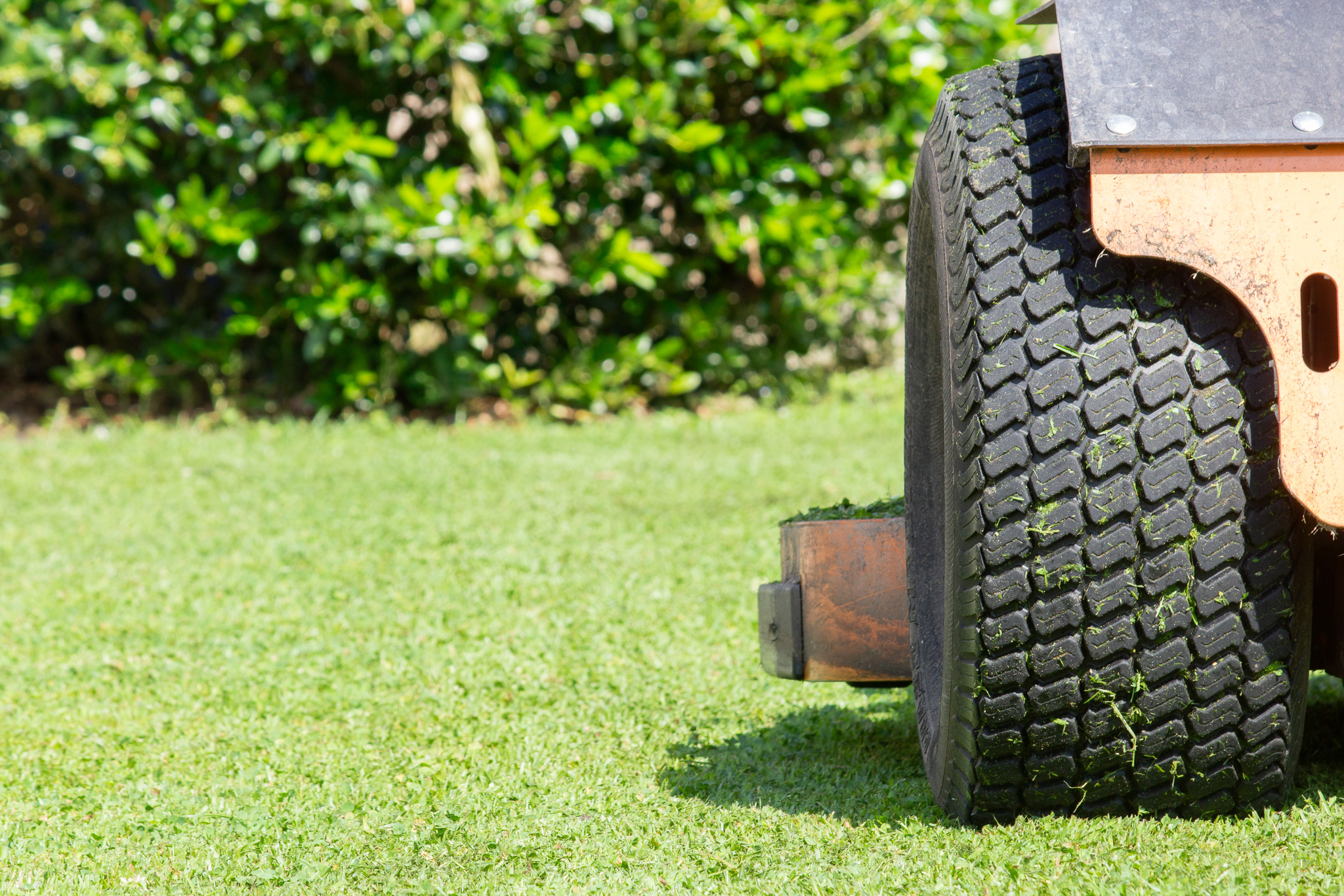 A riding lawnmower mowing a lawn on Tanbark Drive Jacksonville NC.