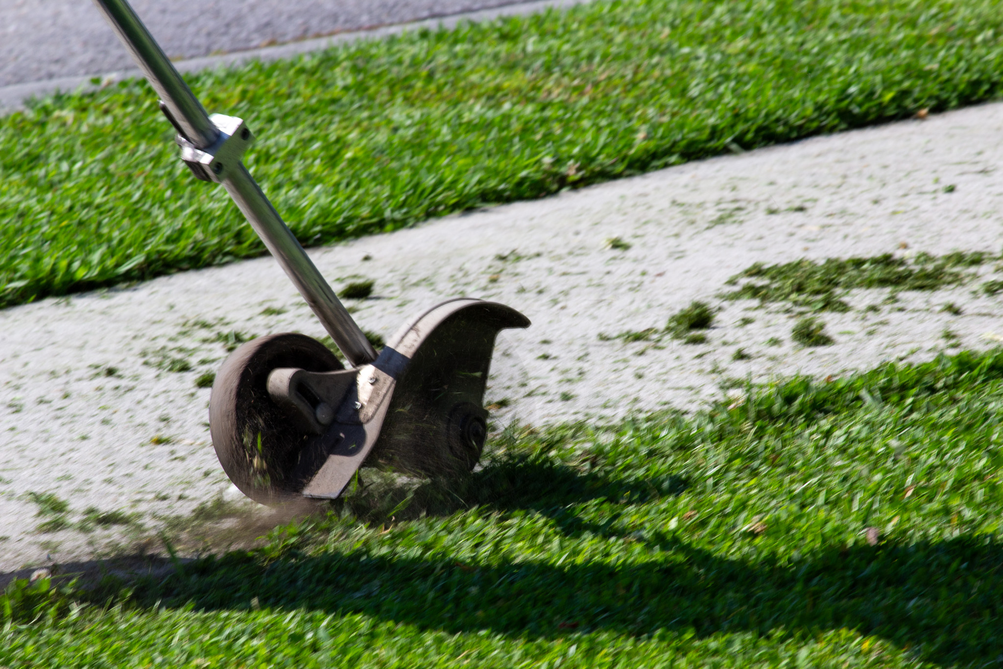 Edging a drive way after mowing the lawn.