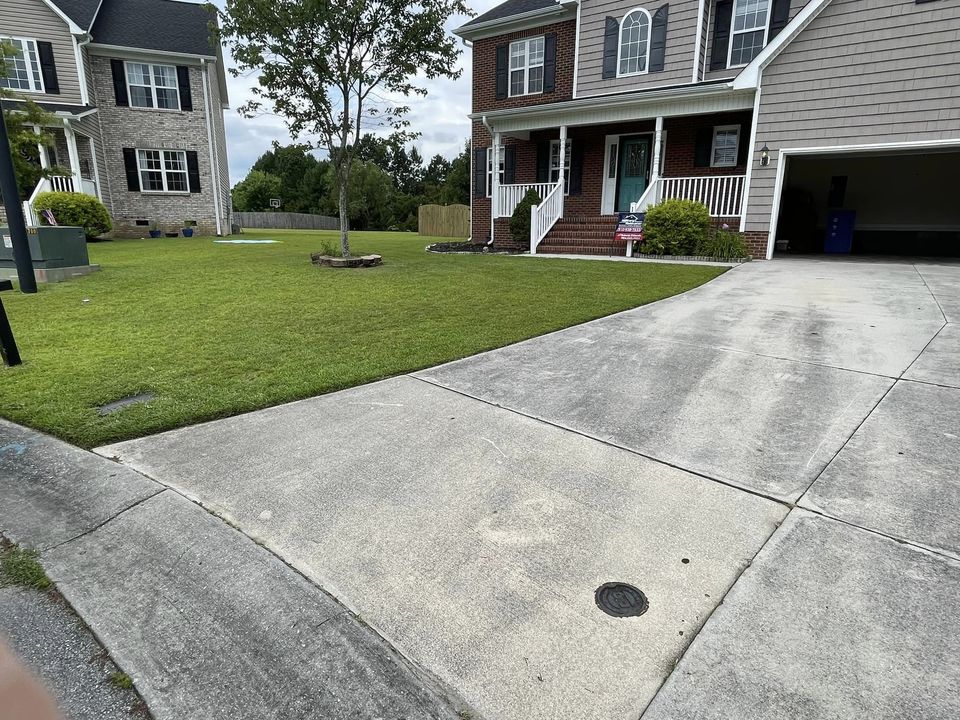 A perfectly mowed, edged and weed eaten driveway. 